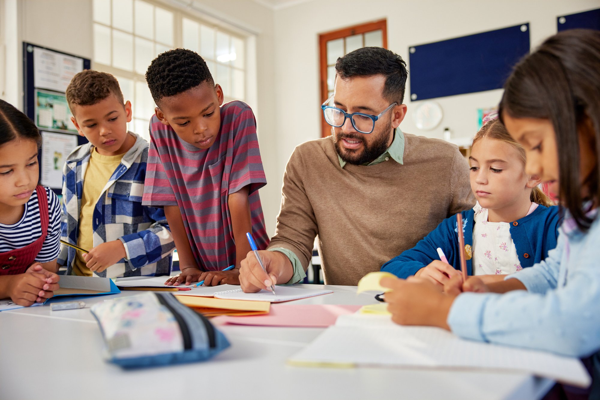 Teacher-checking-pupil-notebooks-2160438108_2123x1416