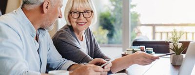 old couple smiling while pointing to computer screen